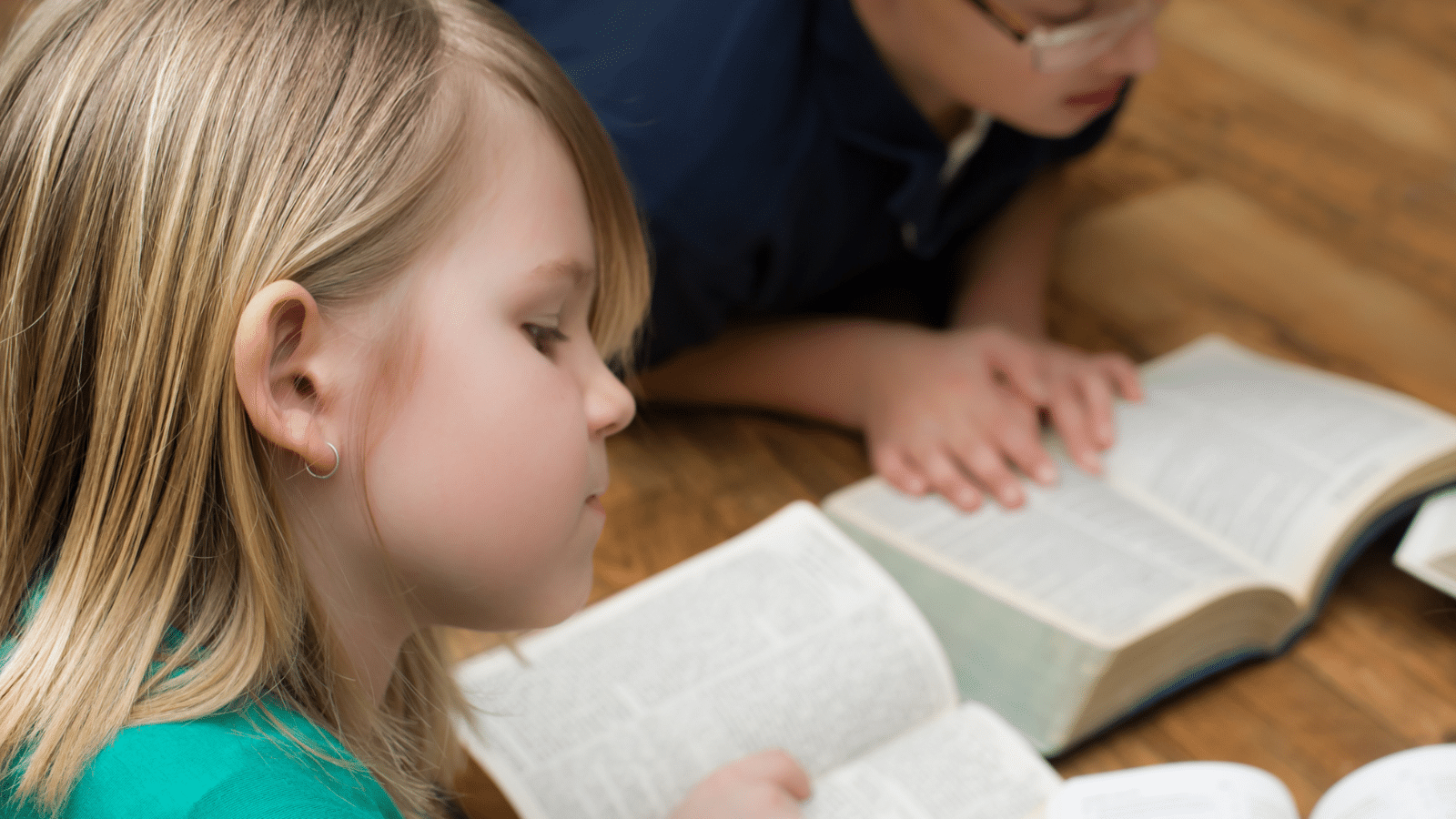 A boy and a girl reading books.