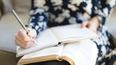 A woman writing in a notebook.