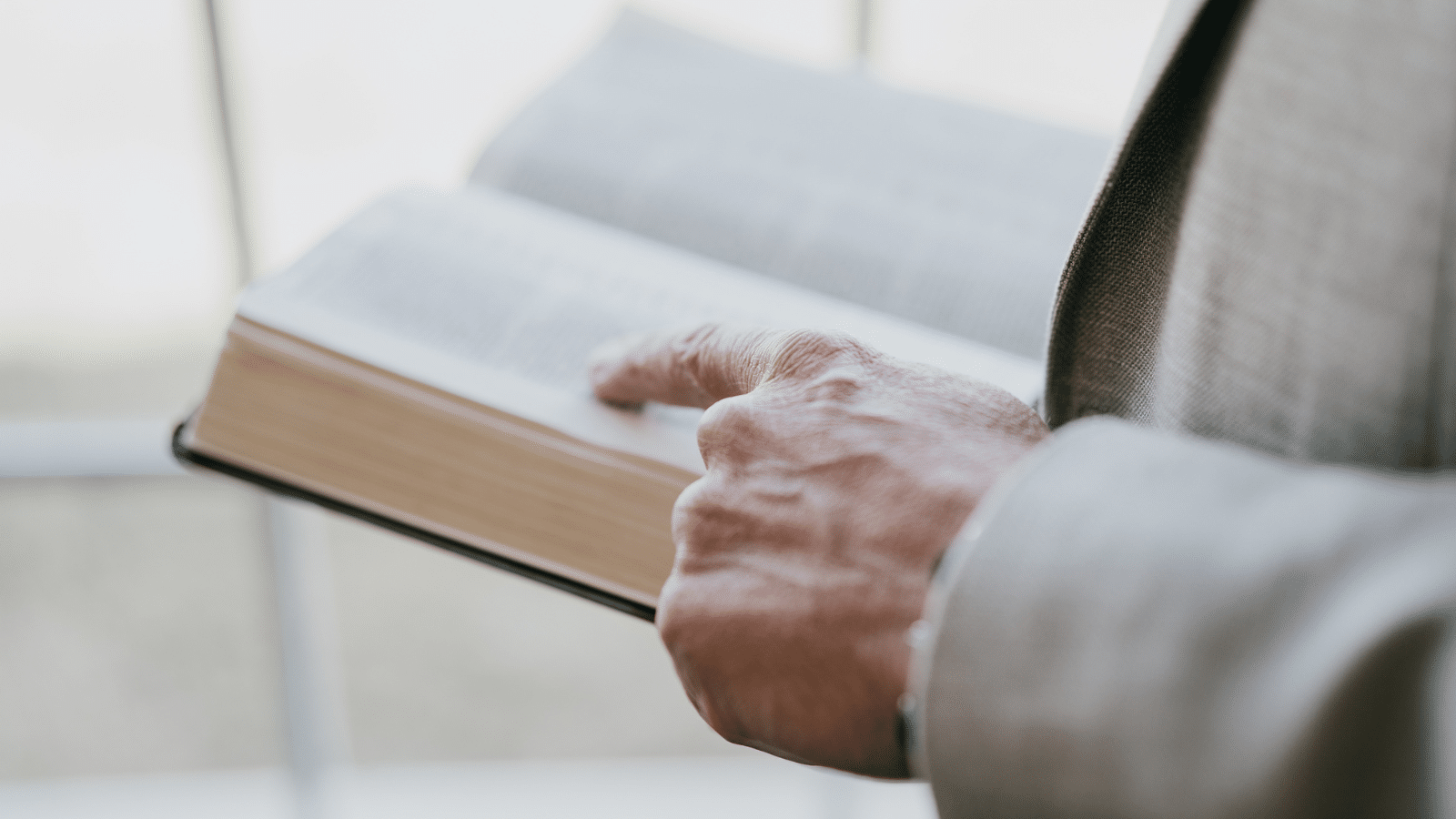 A hand flipping through an open bible.