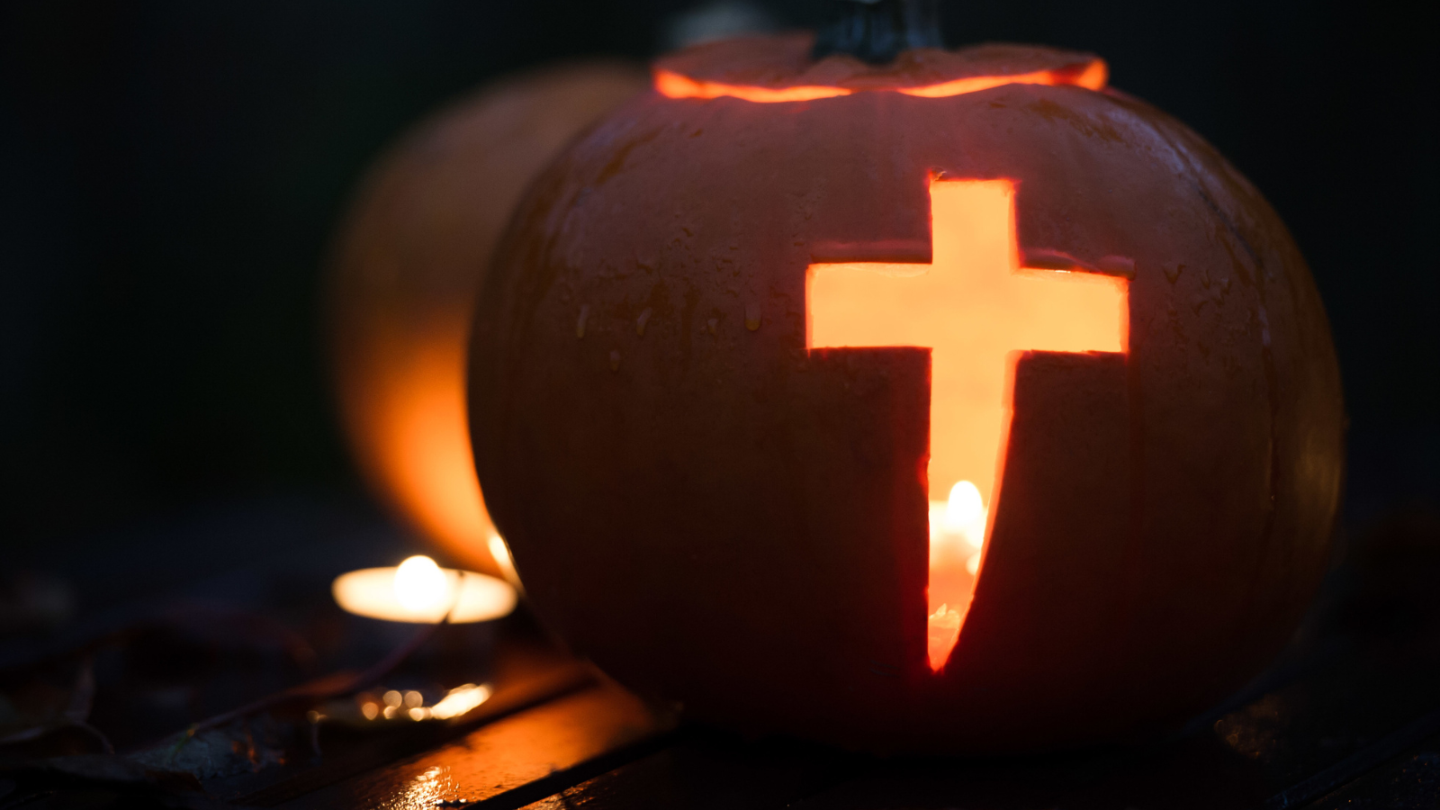 A pumpkin with a cross carved into it.