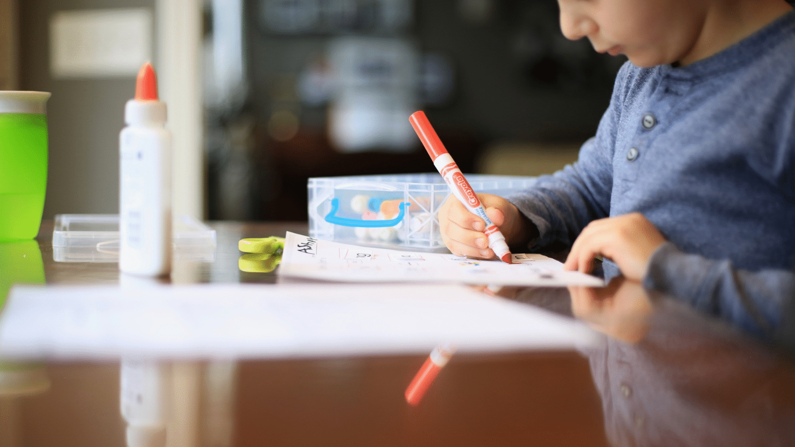 A child sitting at a table coloring.