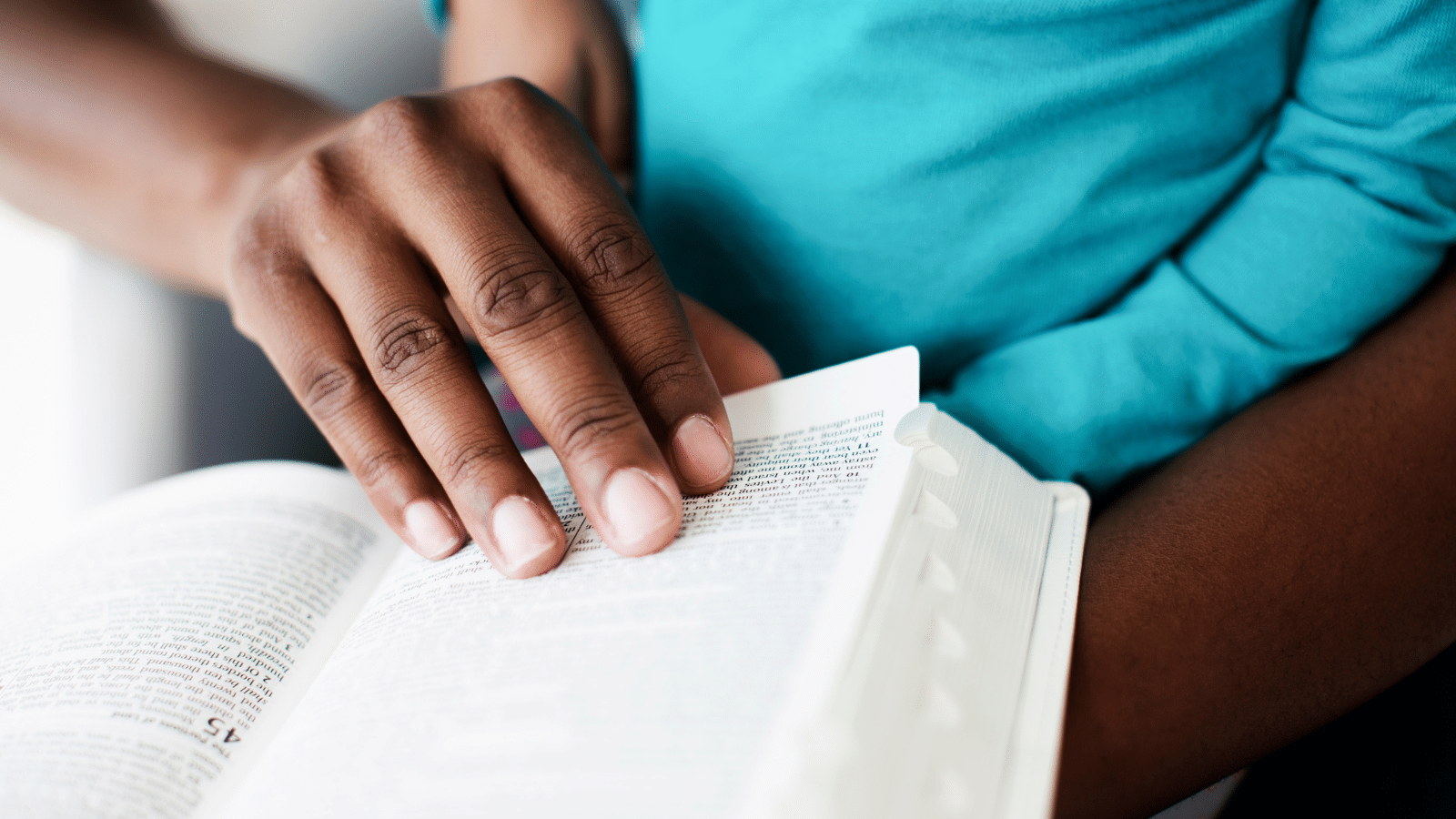 A woman reading the bible with a child.