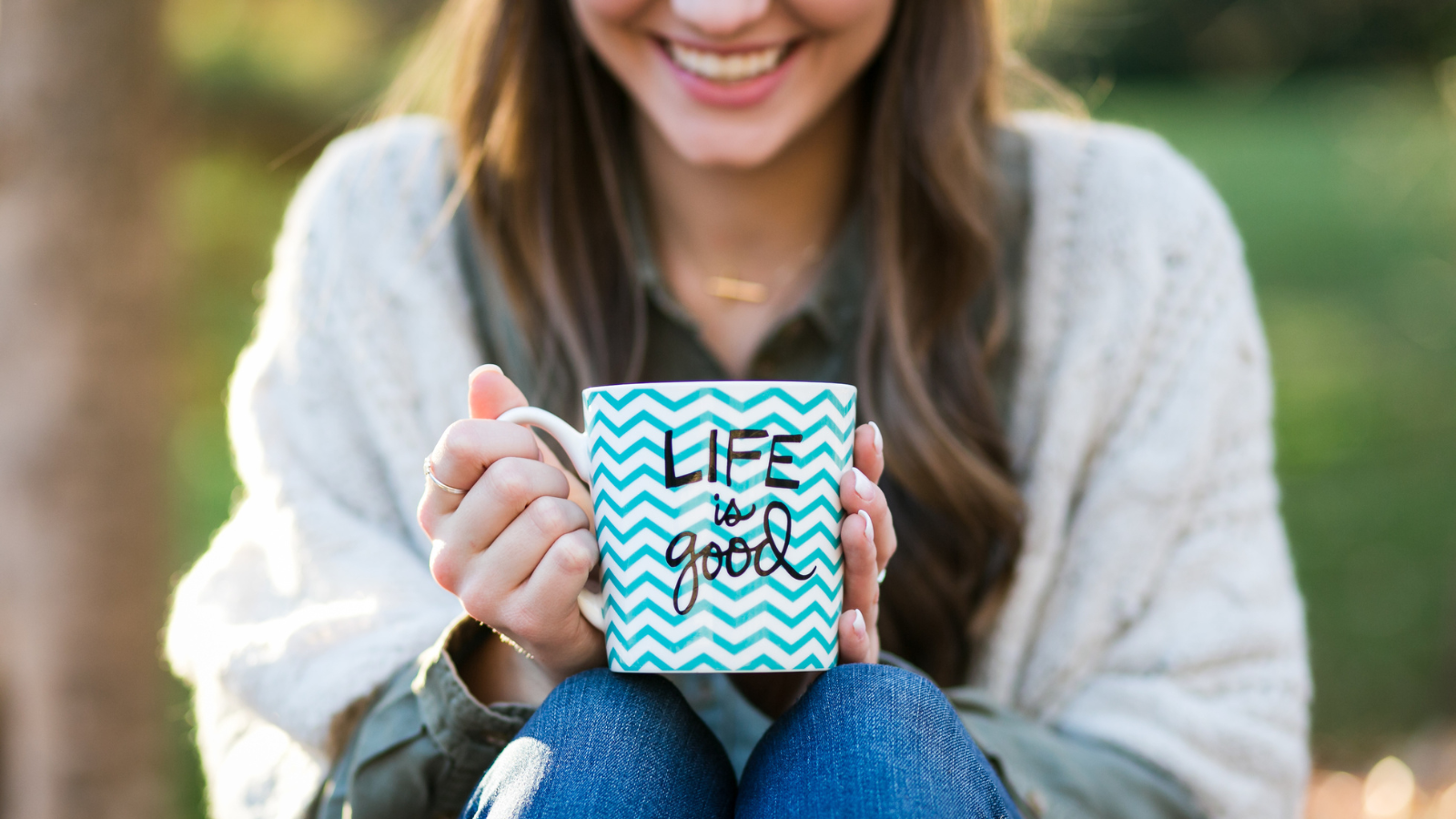 A woman holding a mug that says "life is good".