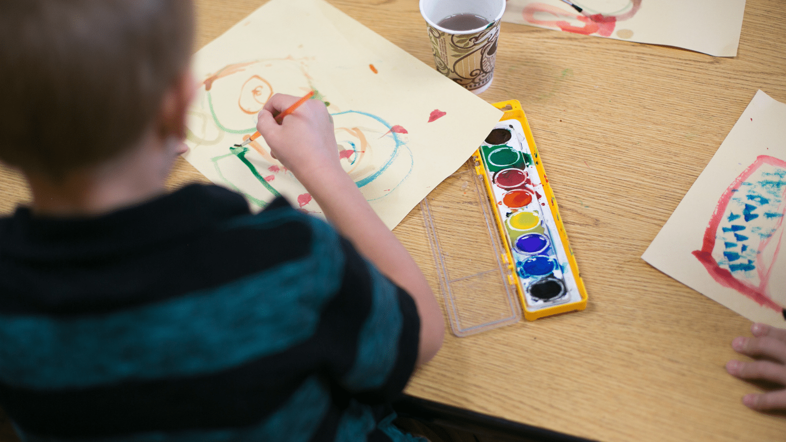 A child sitting at a table painting.