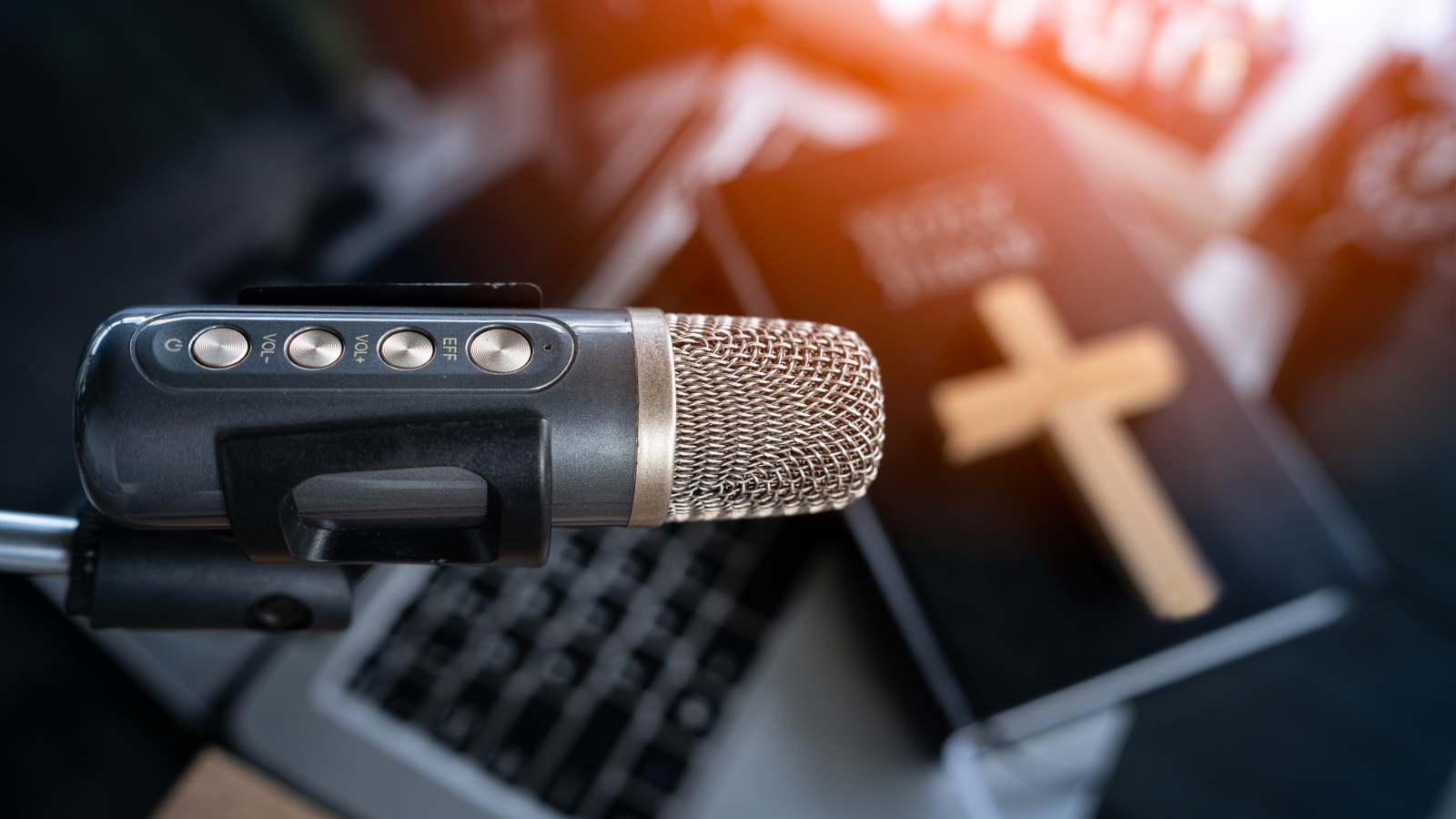 A podcast microphone with a bible in the background.