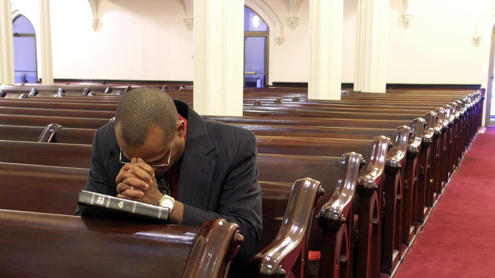 man praying in empty church