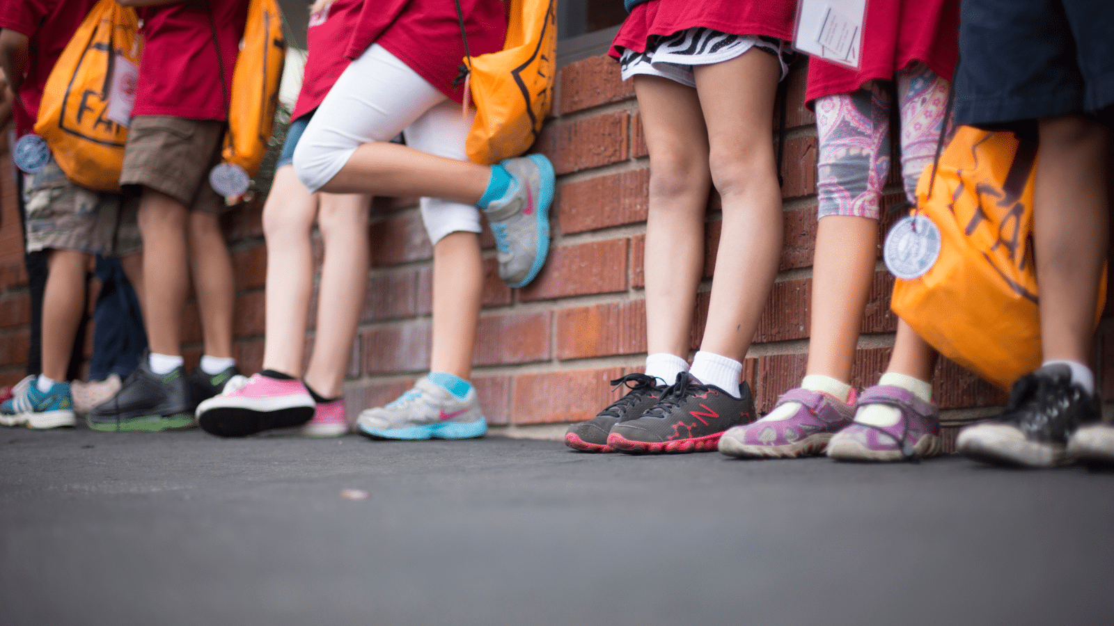 children at school standing against a wall