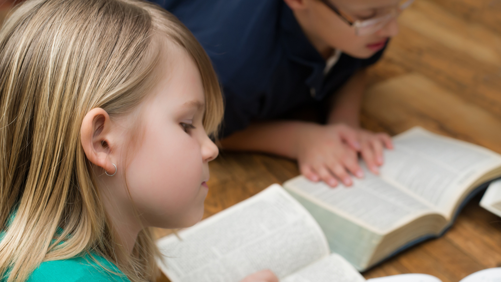 two young children reading the Bible