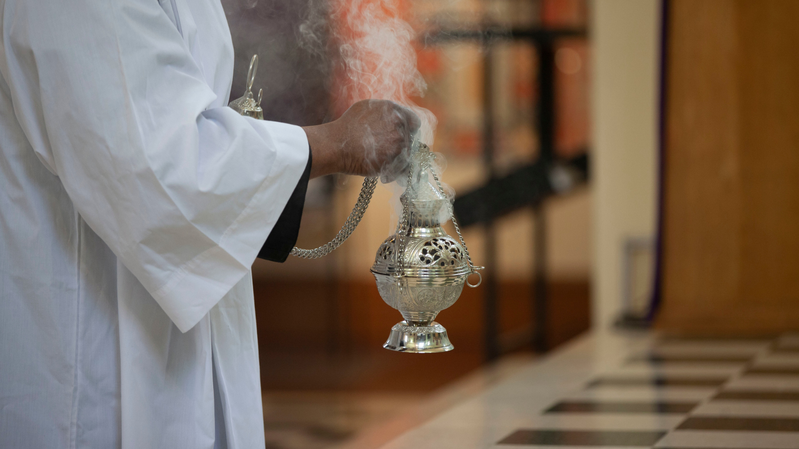 Priest holding container of incense