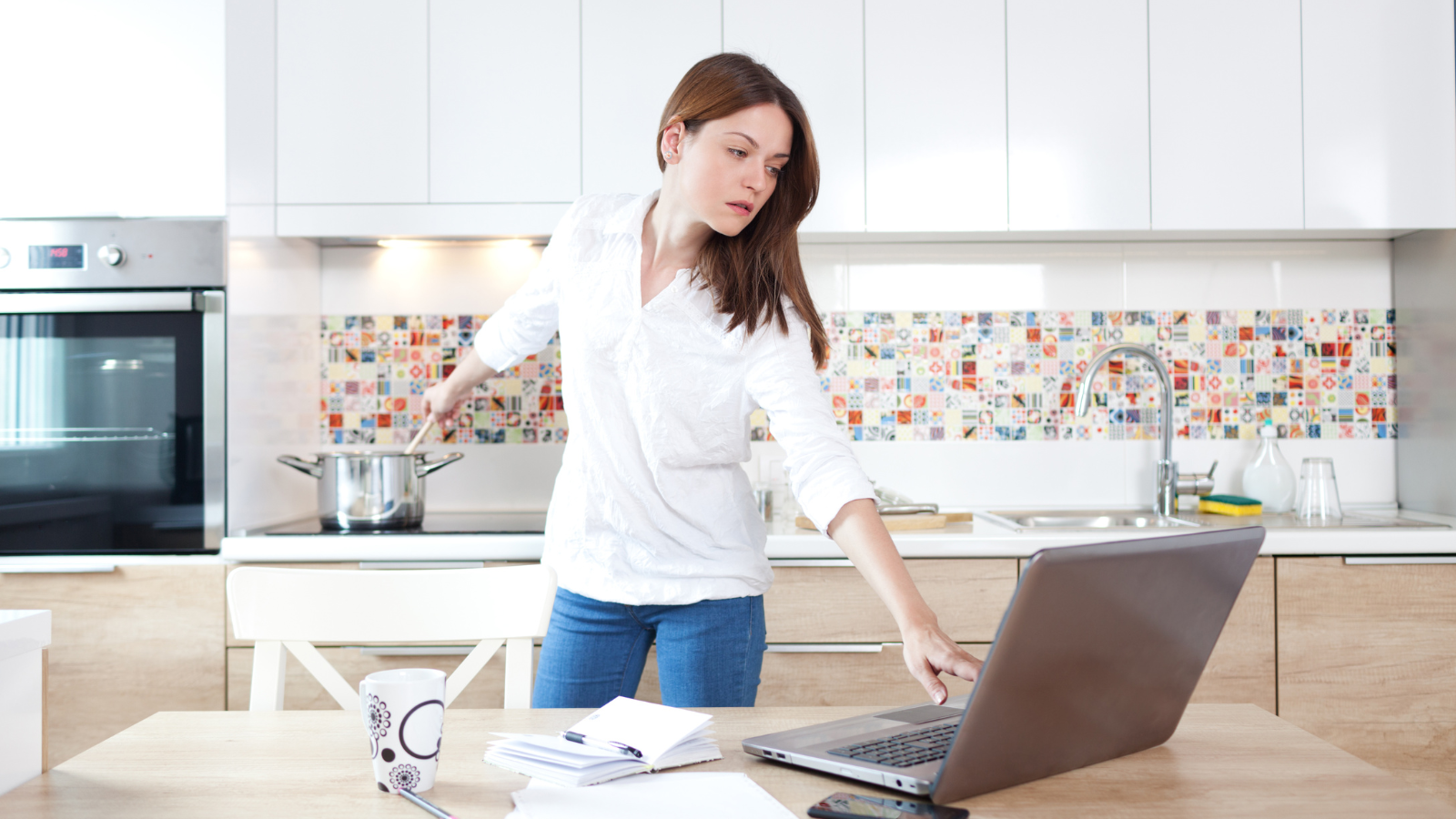 Woman watching computer and cooking