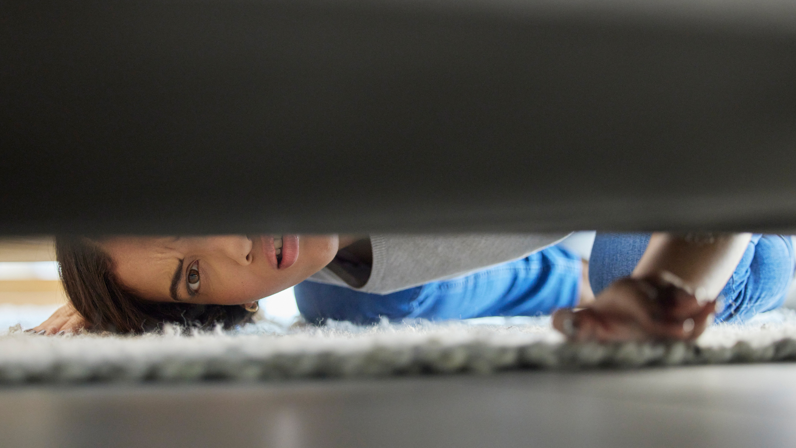 Woman looking under couch