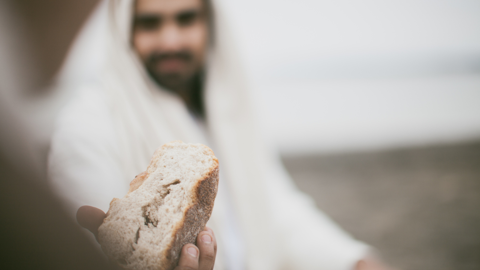 Man who looks like Jesus holding bread