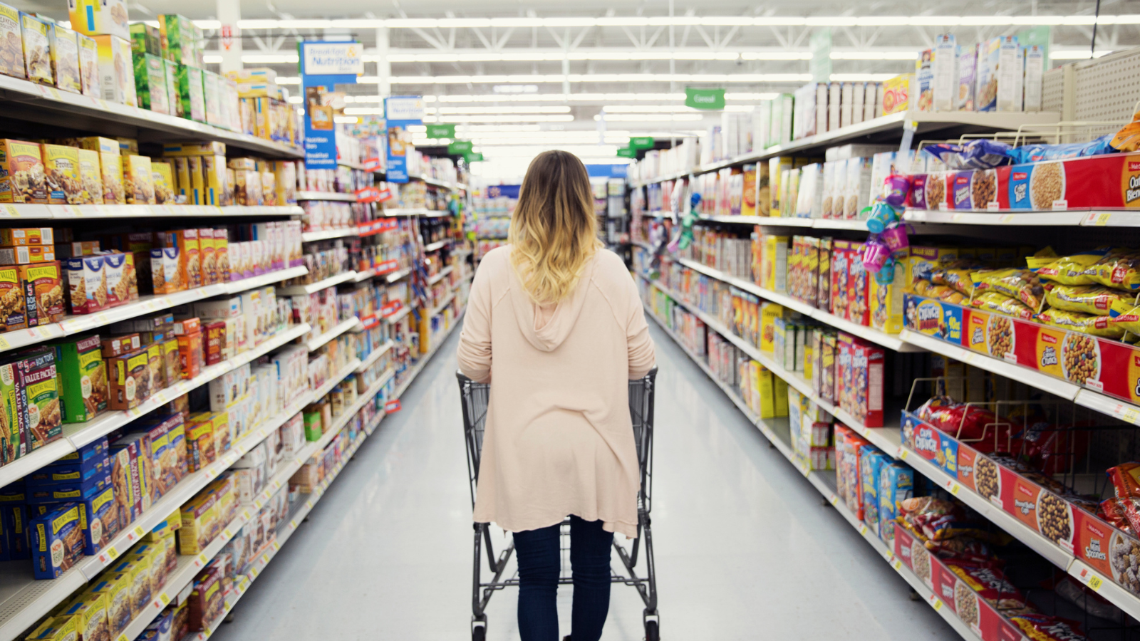 Woman pushing a shopping cart at a grocery store