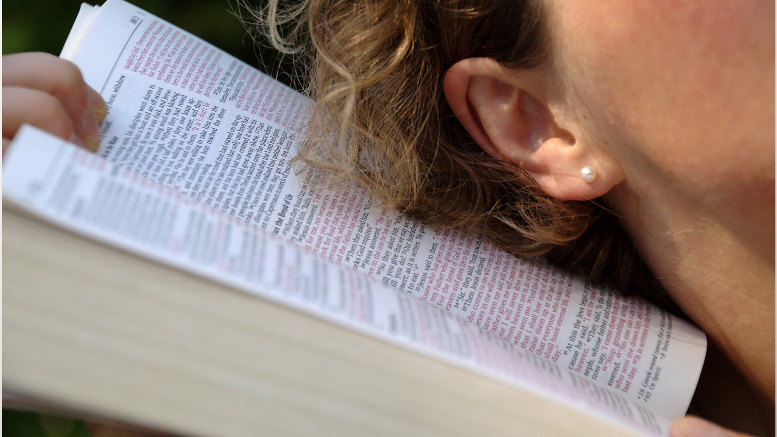 woman lying on Bible