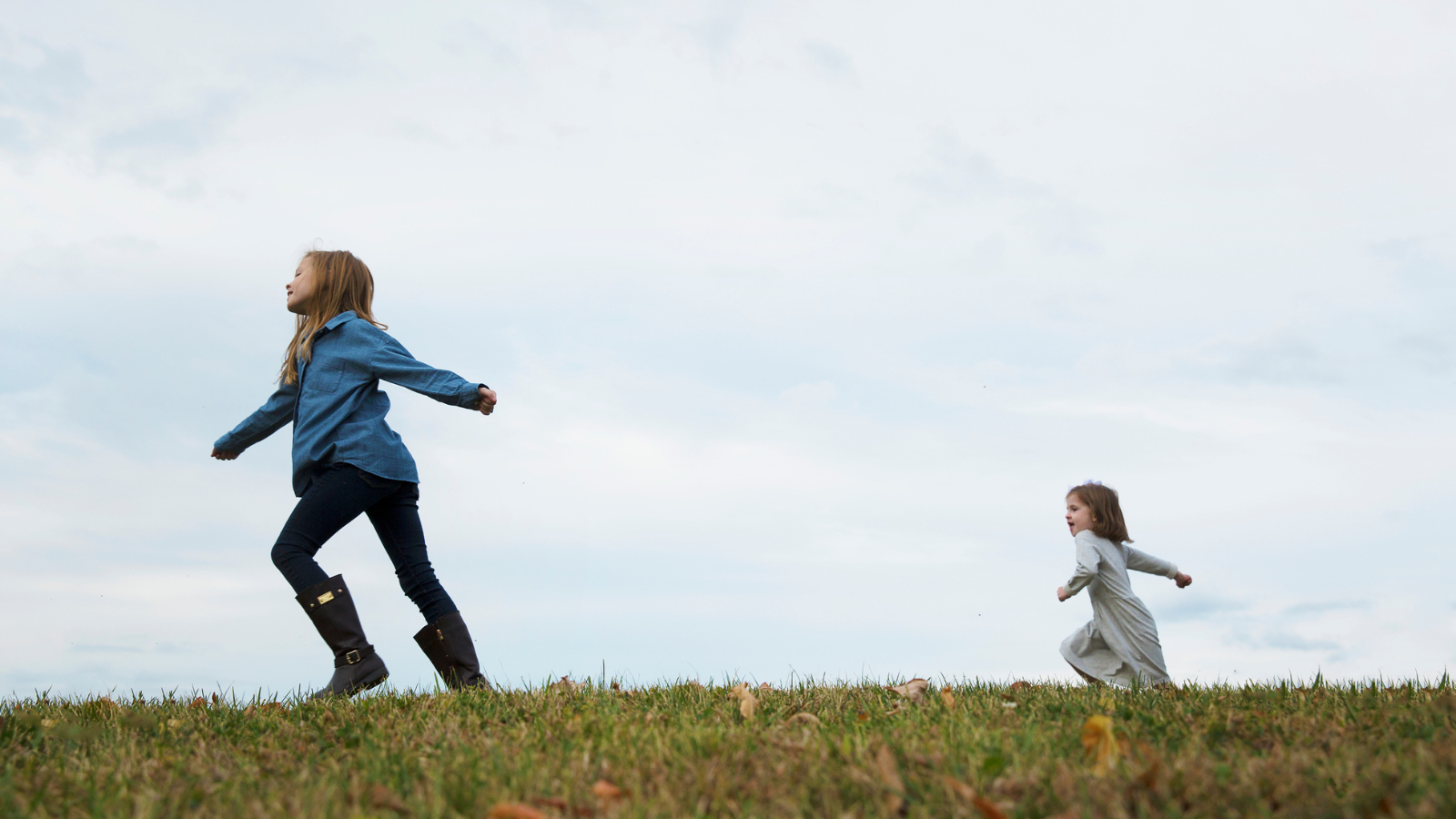 2 girls running in a field