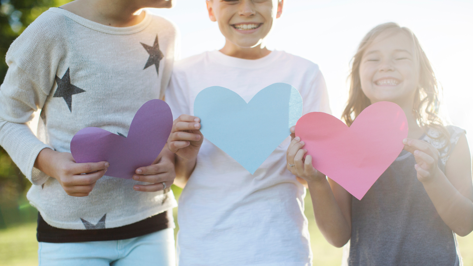 3 kids holding paper hearts
