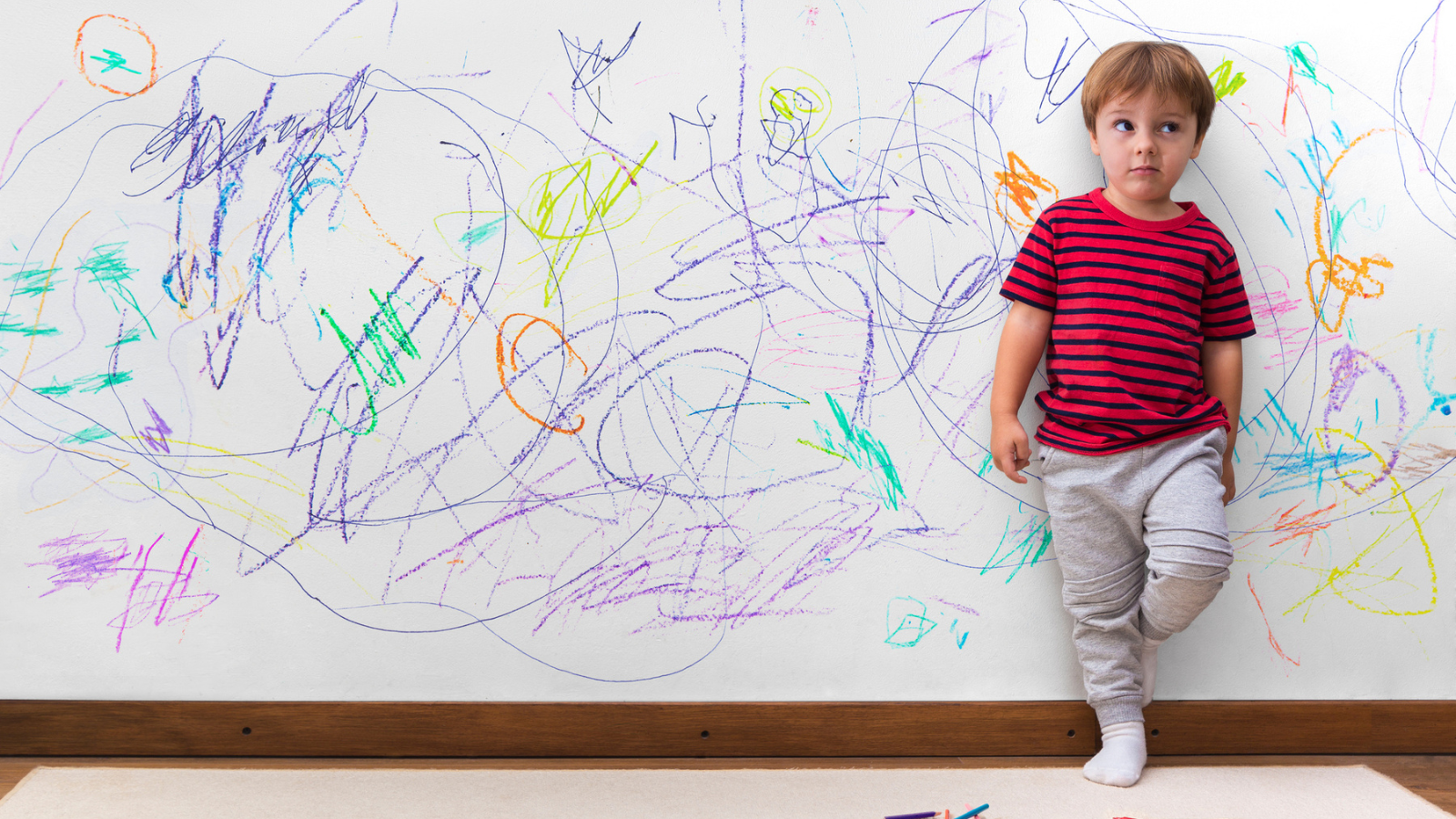 Boy standing in front of a wall he colored