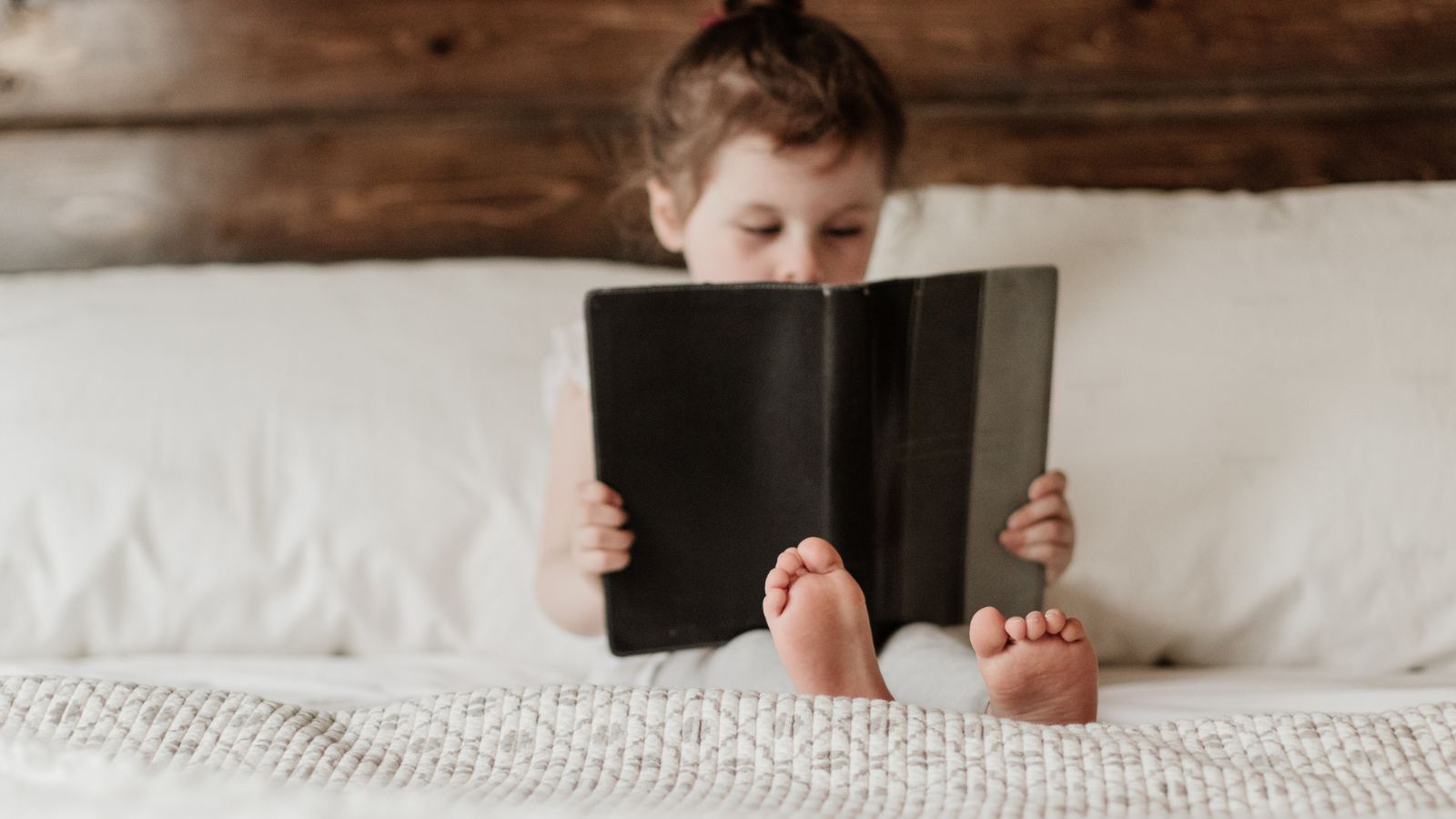 Girl reading a book in her bed