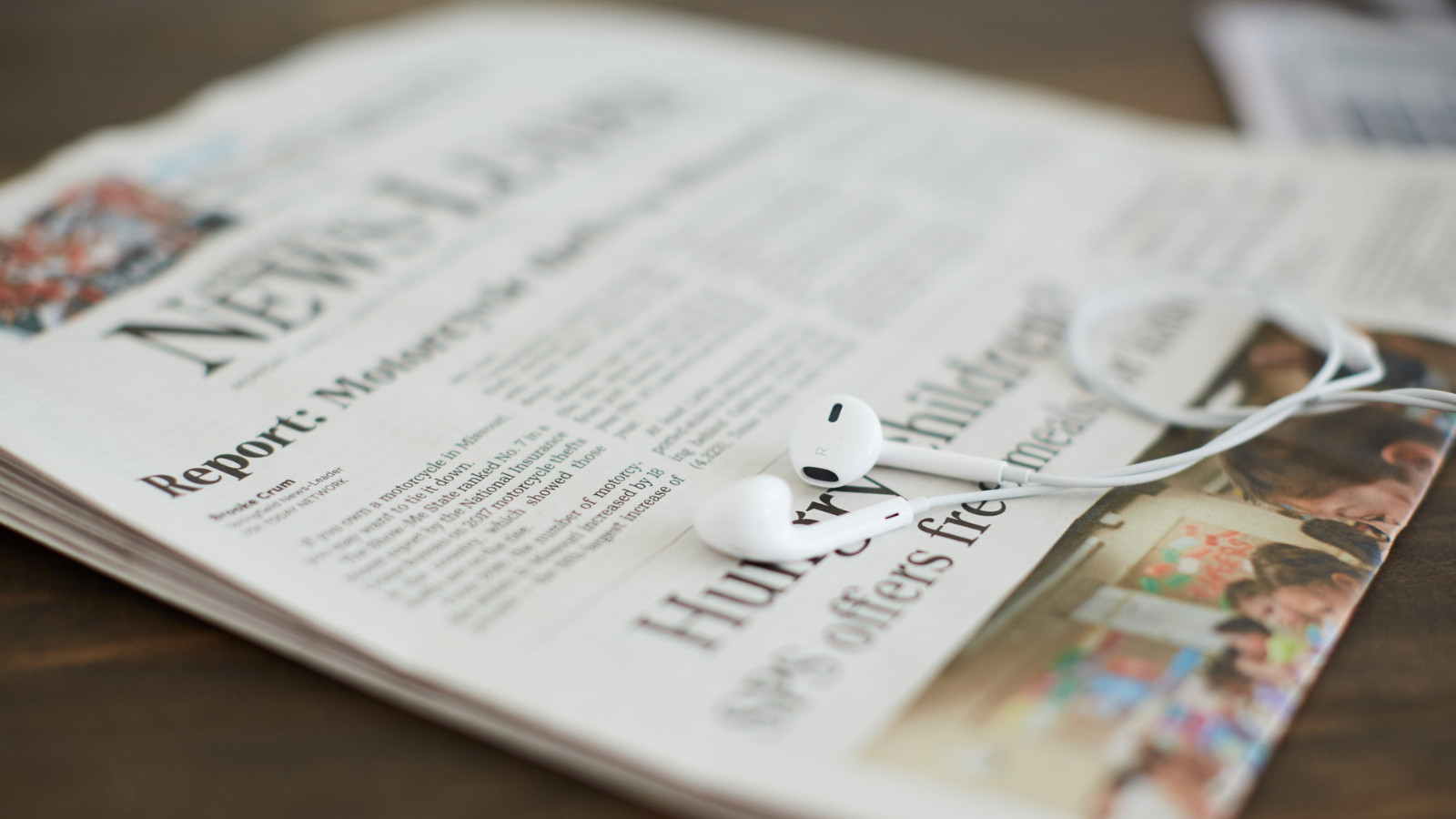 Newspaper with earbuds over it
