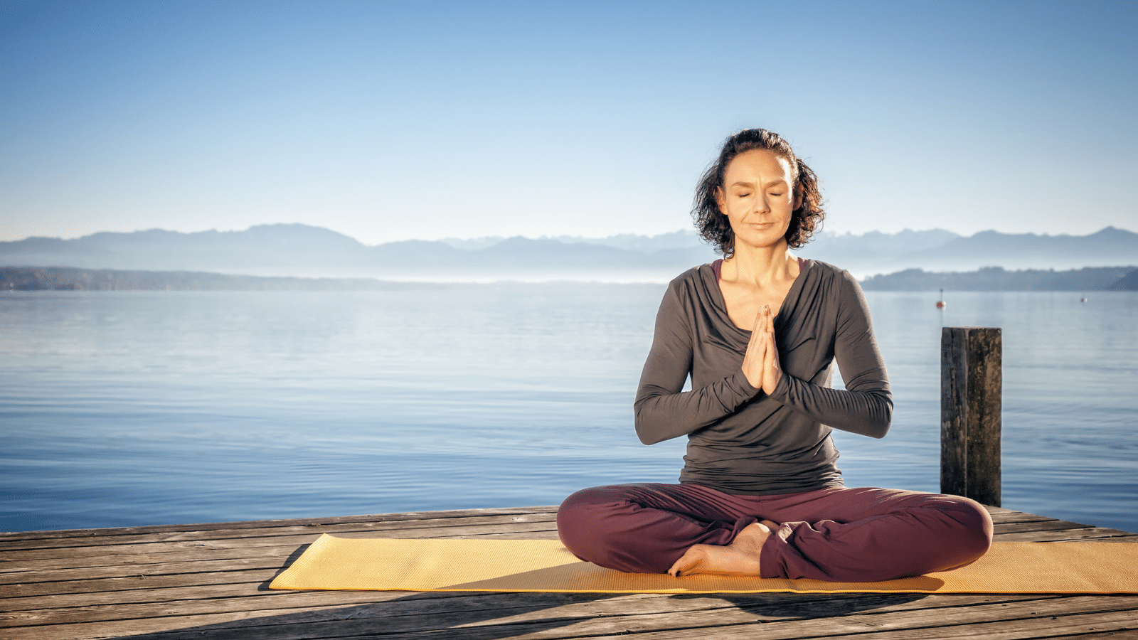 Woman on a dock sitting in a yoga position