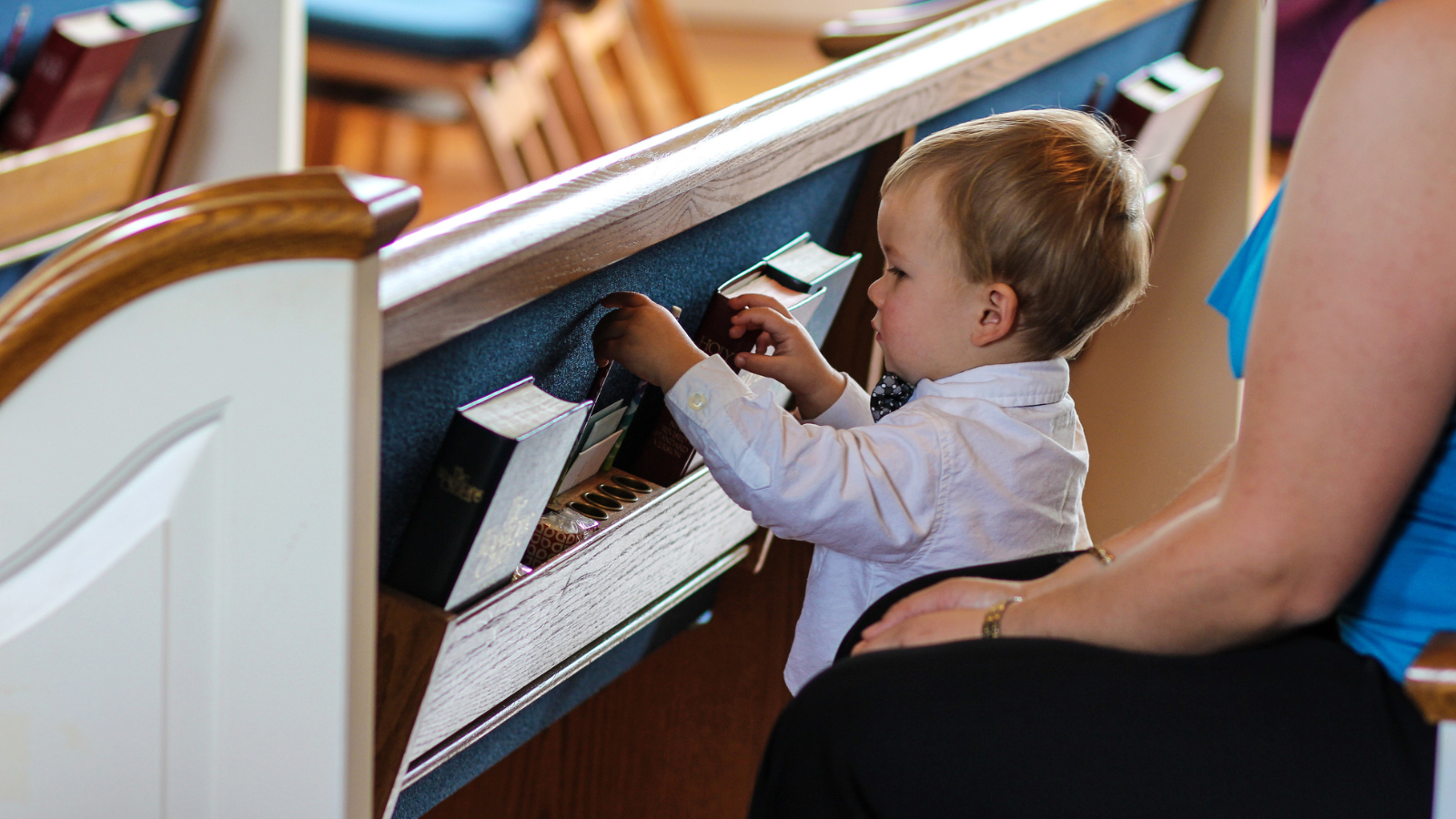 Toddler playing with Bibles in church