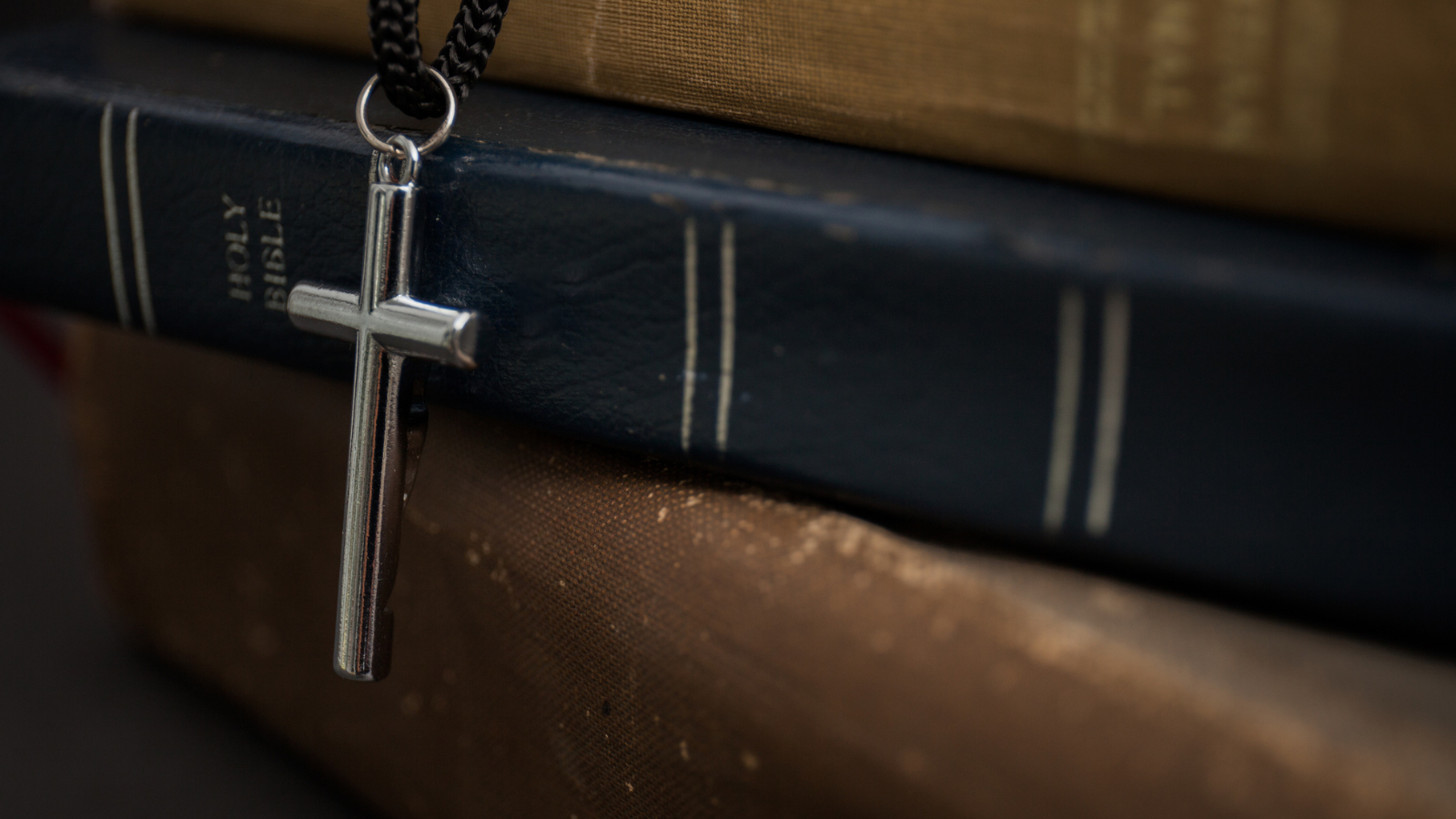 silver cross and Bible
