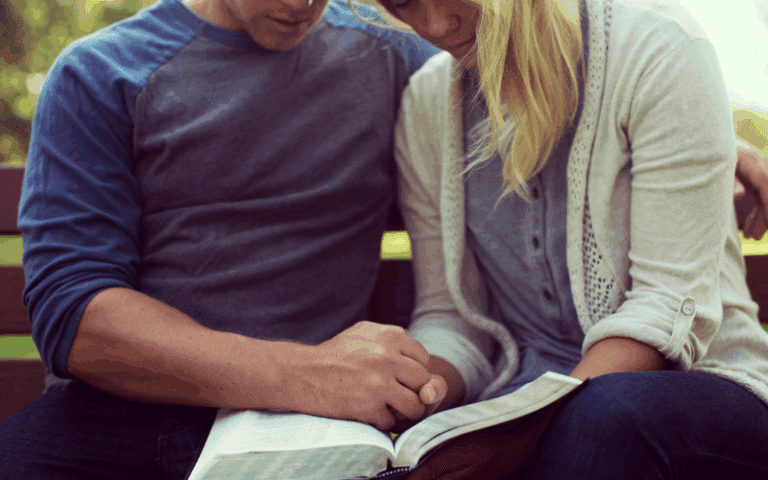Woman praying in front of a Bible